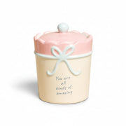 Cream ceramic candle with pink scalloped lid and blue bow, lid on