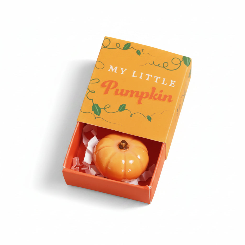 Ceramic pumpkin token in an open My Little Pumpkin matchbox on cream