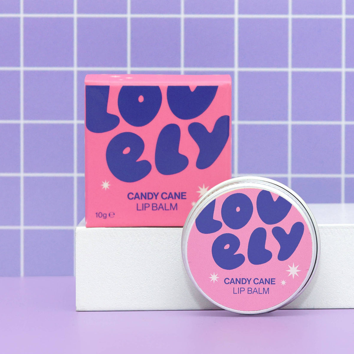 Candy Cane lip balm tin and box on a lilac grid