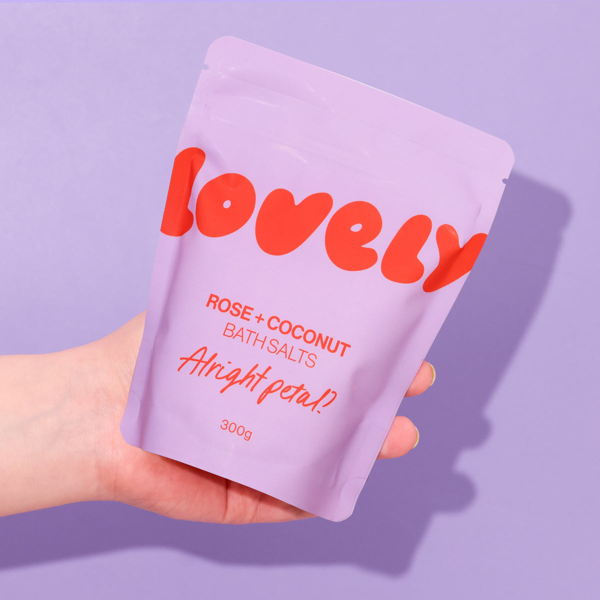 Hand holding the Rose and Coconut bath salts pouch