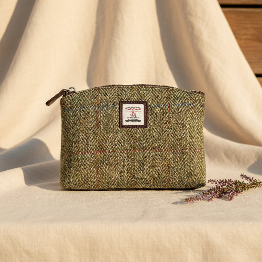 Green herringbone patterned pouch with a visible brand label on a white background