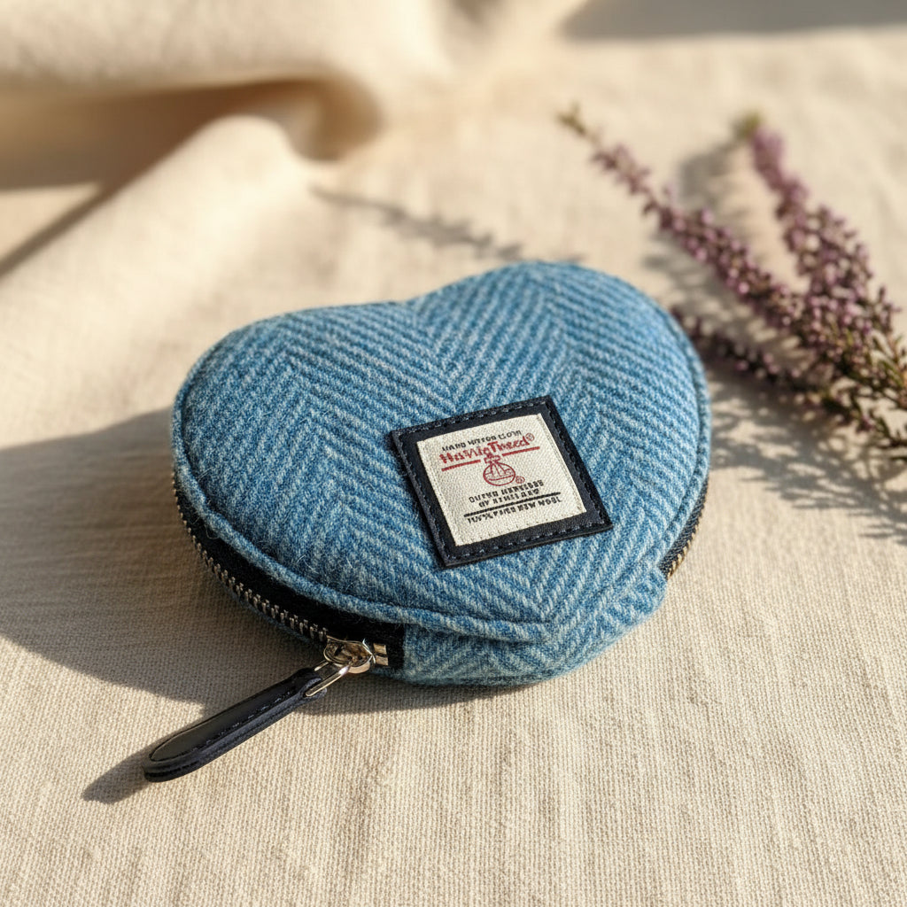 Heart-shaped blue fabric pouch with a visible brand label on a white background