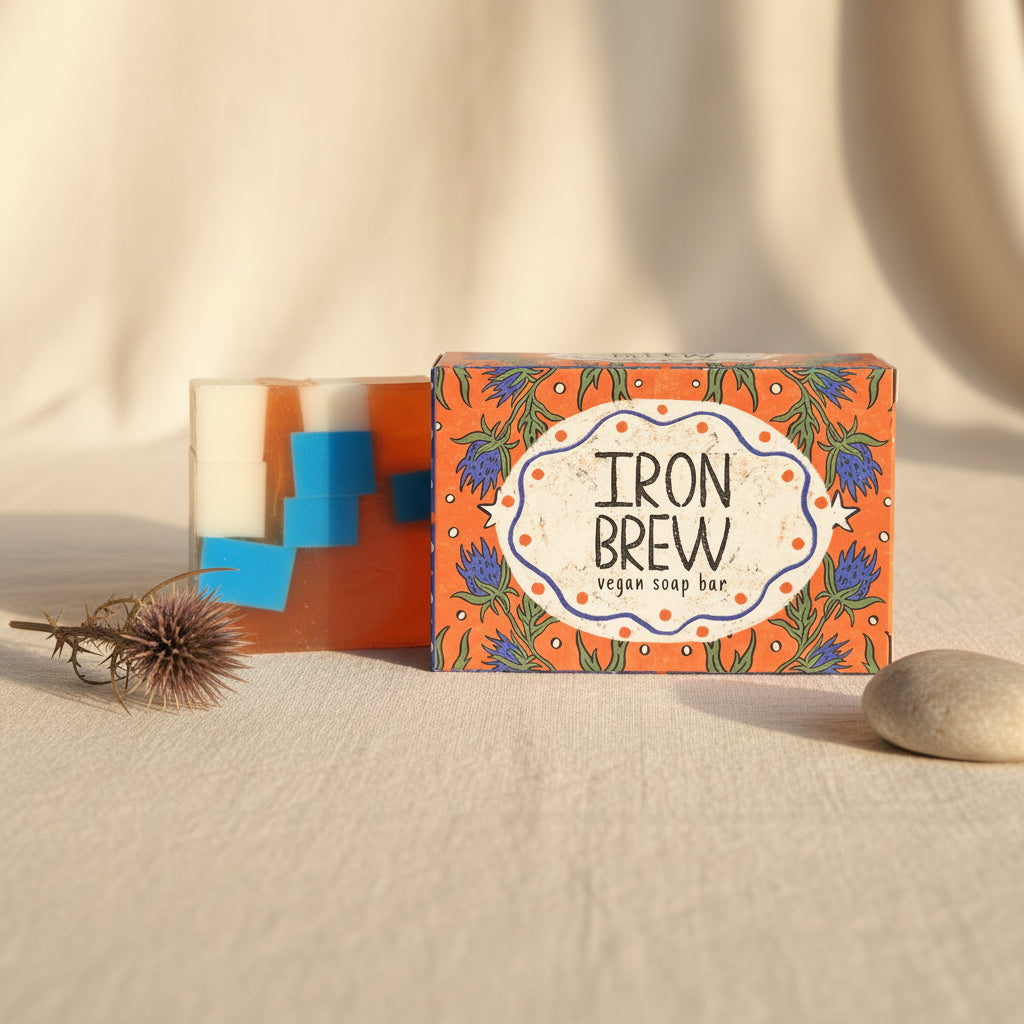 Vegan soap bar with 'Iron Brew' branding on an orange packaging with blue accents.