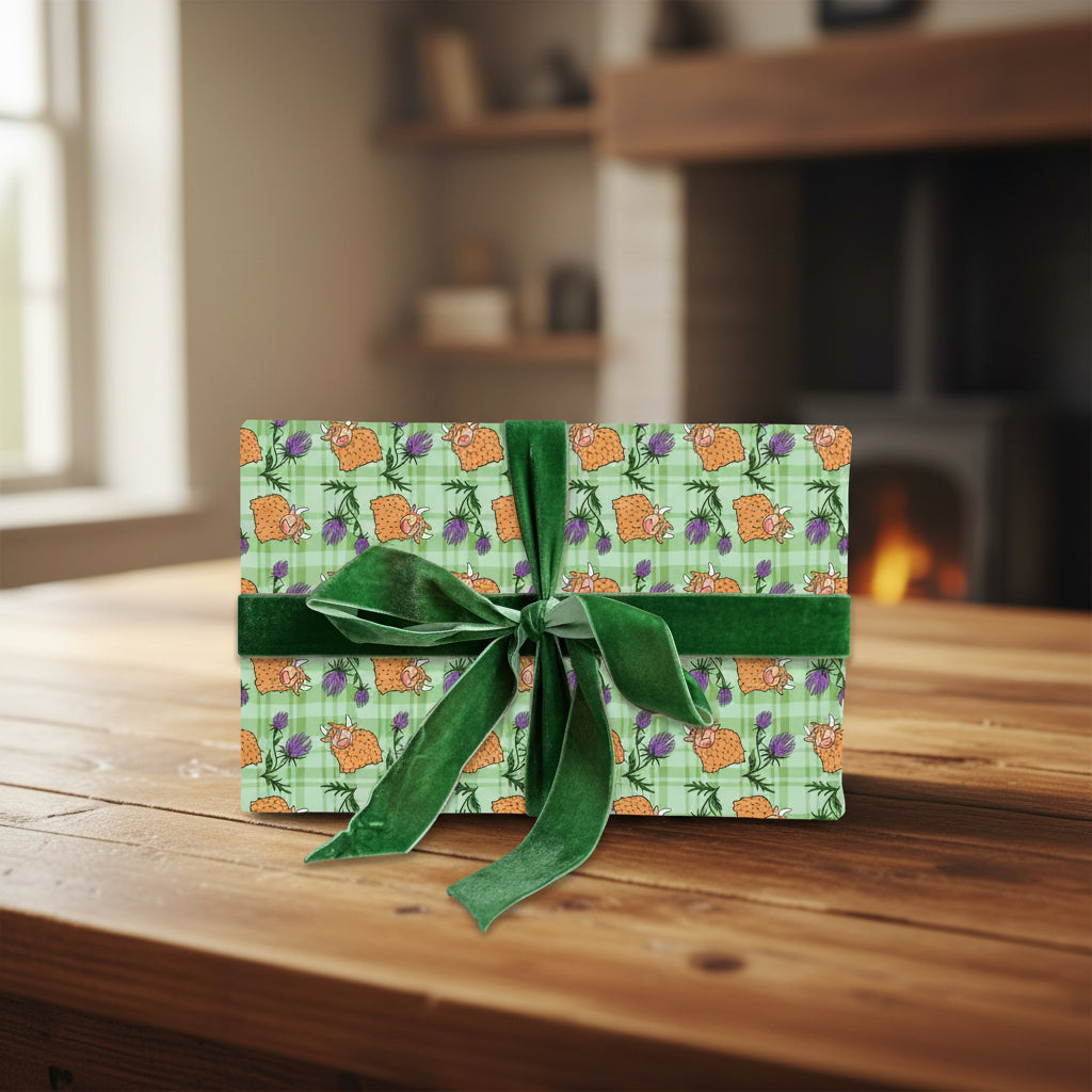 Tartan Highland cow wrapping paper on a gift tied with green ribbon