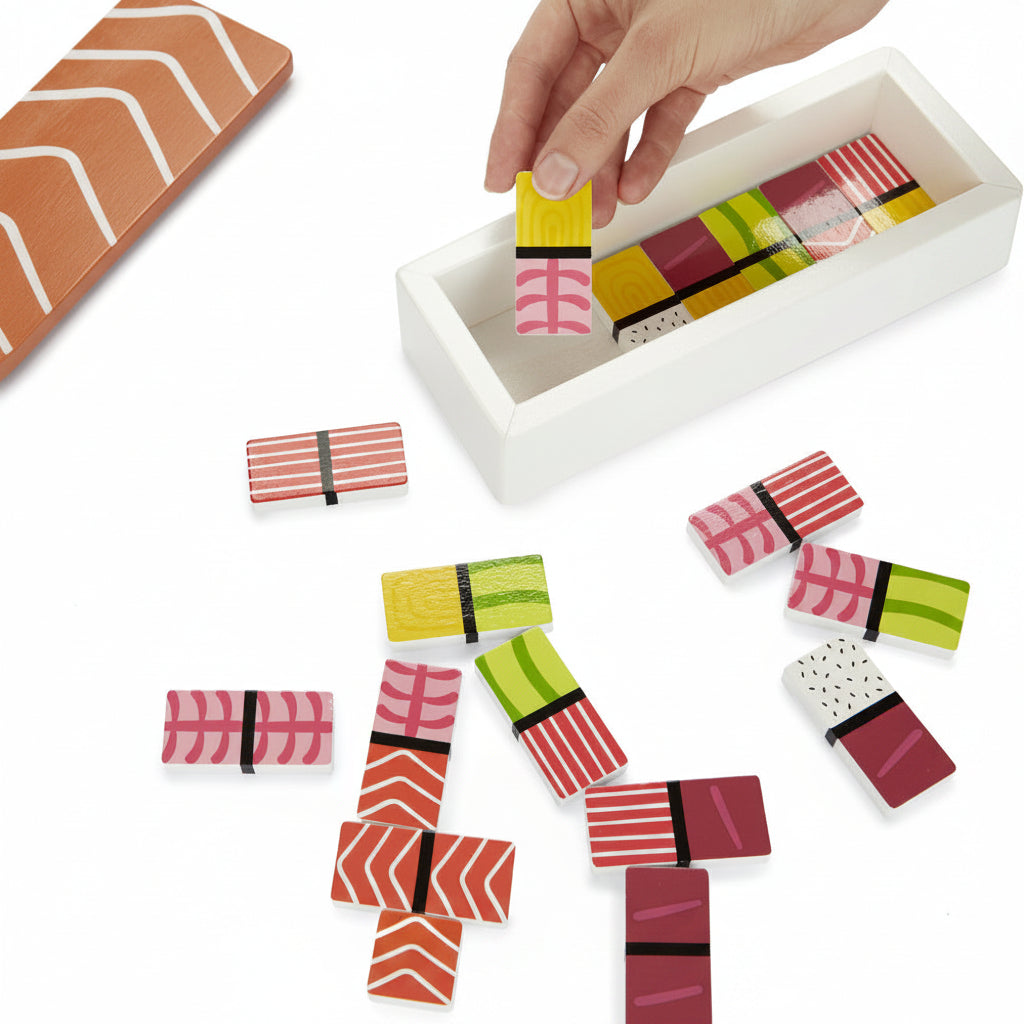 Sushi dominoes scattered with box open on white background