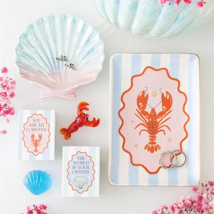 Pastel shell trinket dish on vanity with makeup and jewellery