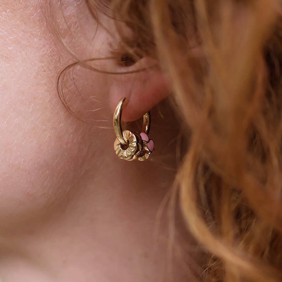 Gold and pink enamel heart hoop earring worn, with auburn hair