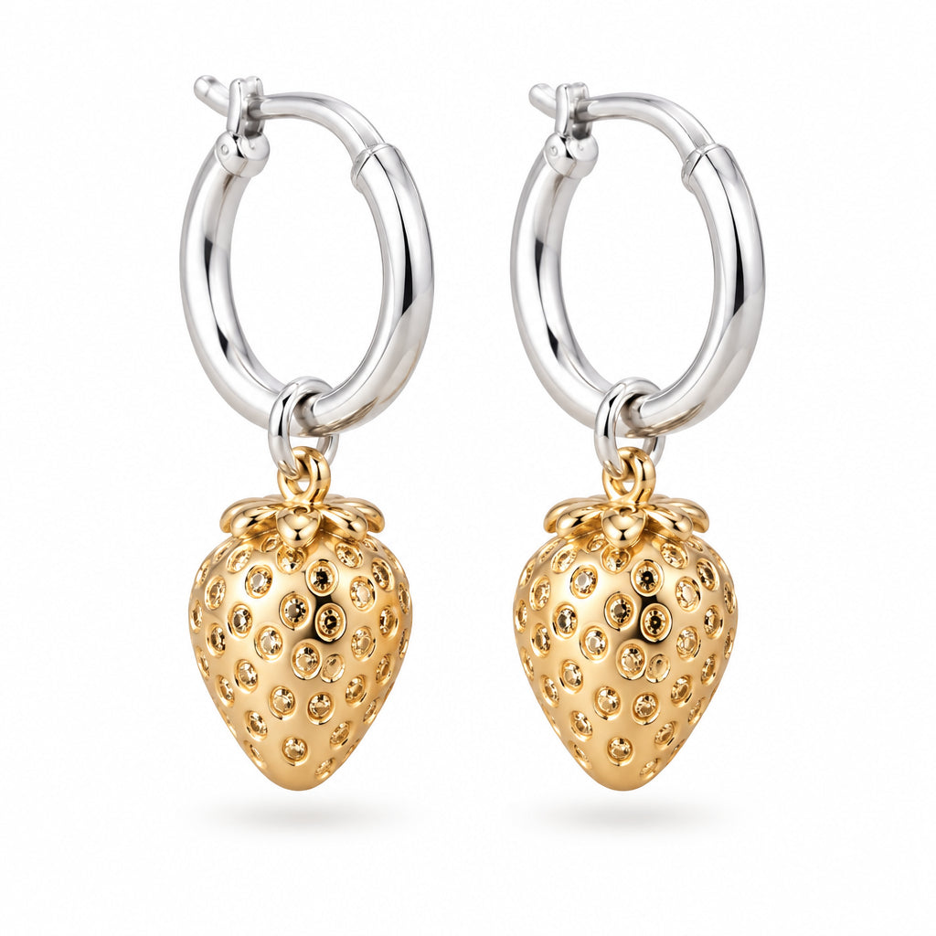 Silver hoop earrings with gold strawberry charms on a cream surface