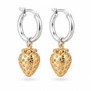 Silver hoop earrings with gold strawberry charms on a cream surface
