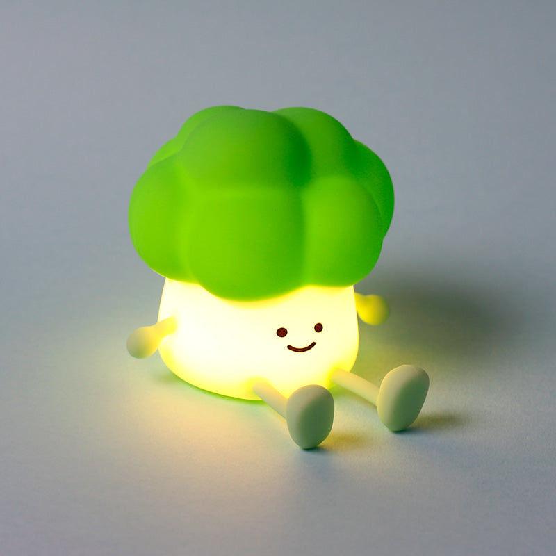 Green silicone broccoli night light glowing warmly with a smiling face