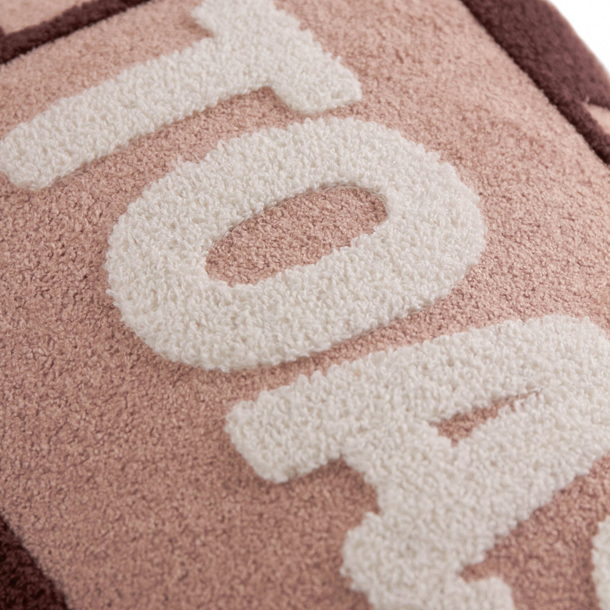 Close up of the cream Toasty lettering on pink boucle