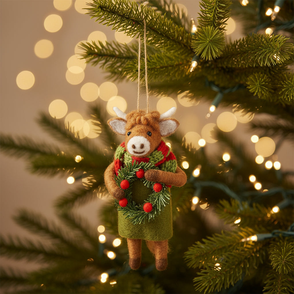 Highland Cow with Wreath Felt Decoration on soft cream linen with dried winter foliage behind