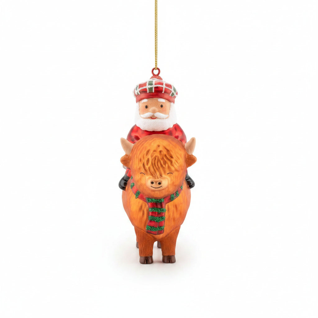 Glass bauble of Santa in a tartan hat riding a ginger Highland cow