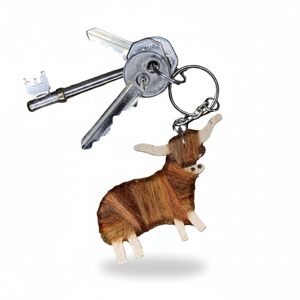 Keychain shaped like a brown goat with two keys attached on a white background