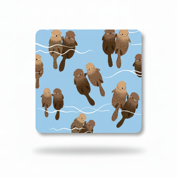 Pale blue coaster with pairs of otters floating and holding paws