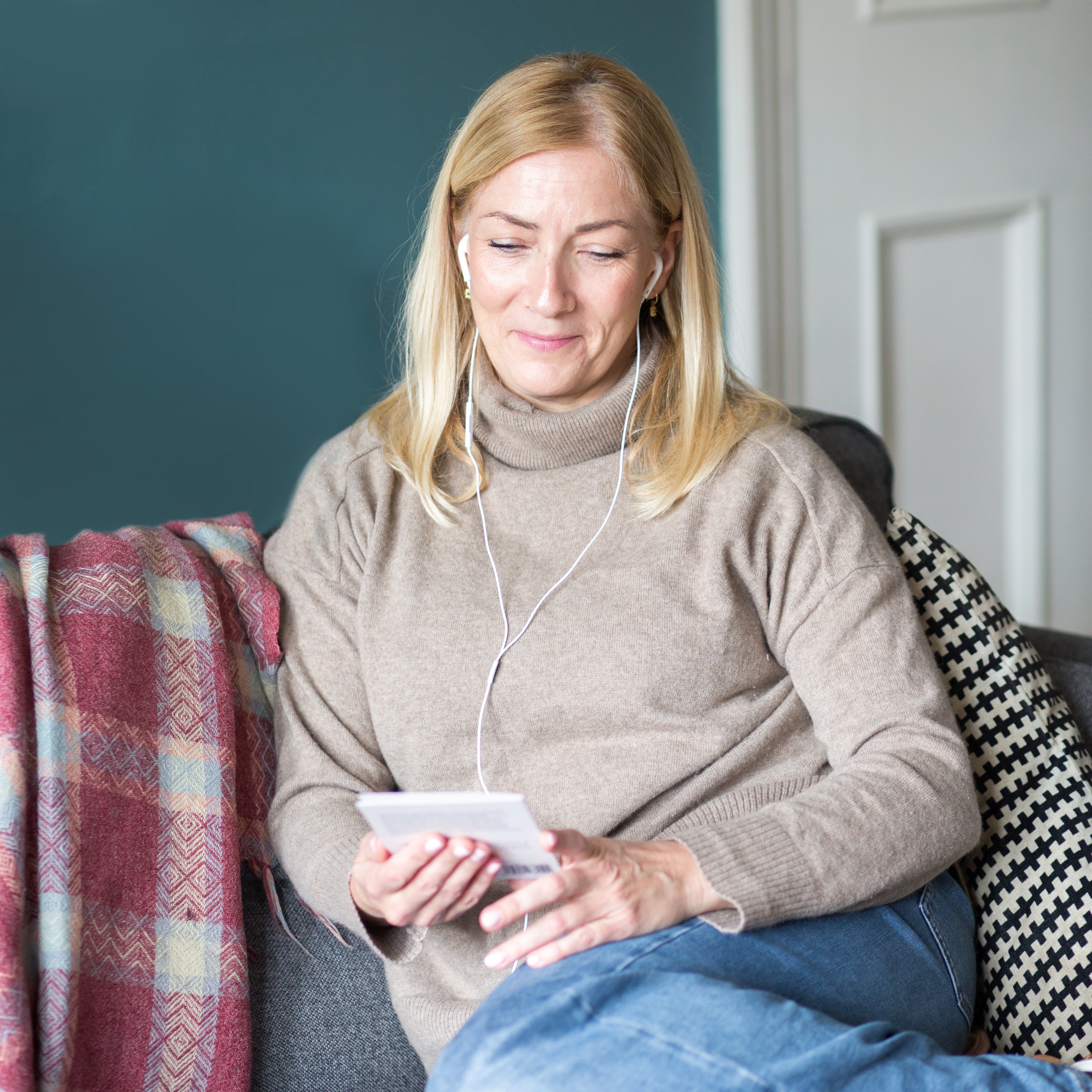 Woman listening to a Spiracle audiobook through headphones after scanning the card