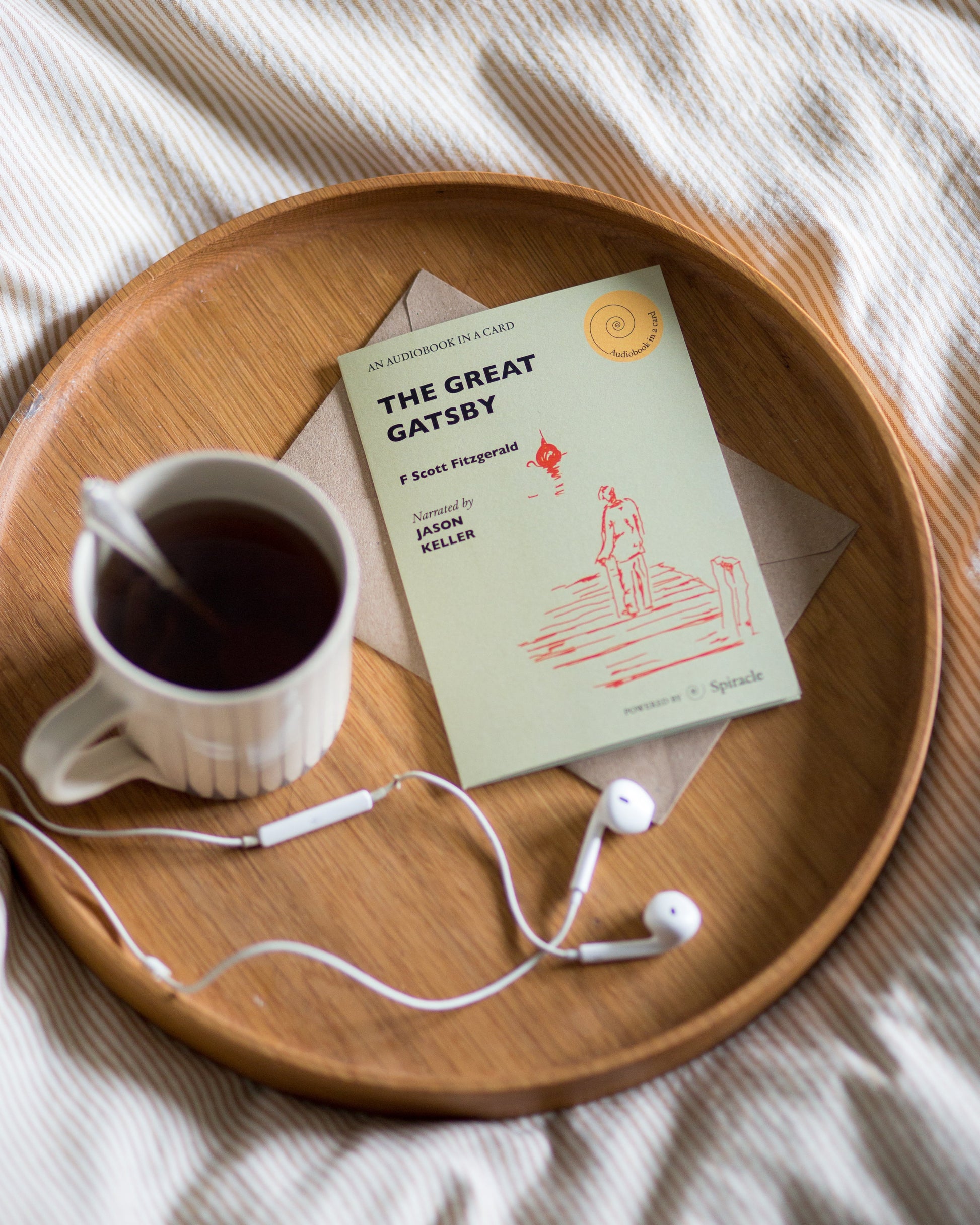 The Great Gatsby audiobook card beside a cup of tea