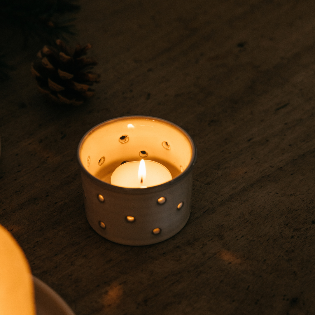 Inspiritus Christmas tealight lit and glowing in a holder