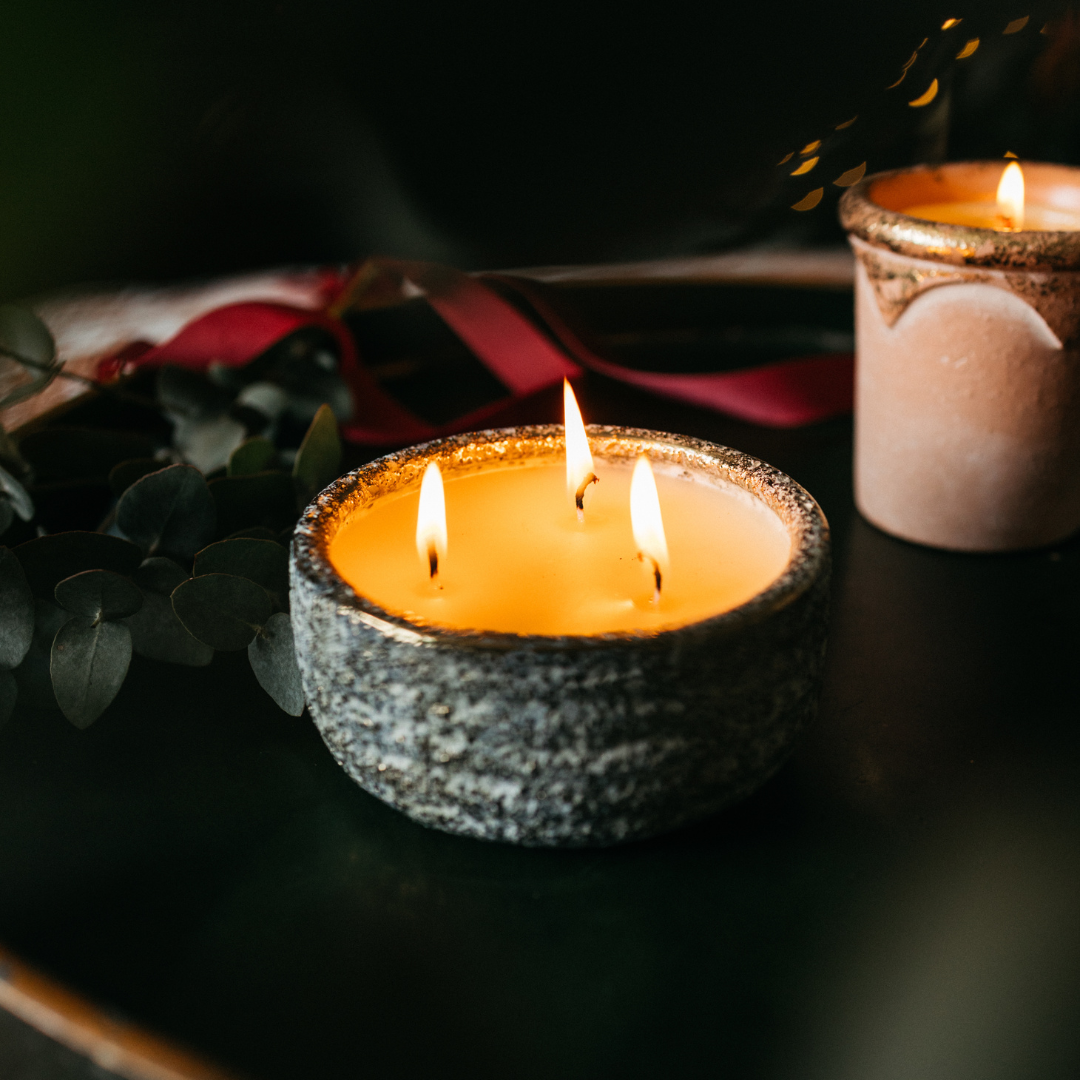 Inspiritus Small Alchemy Pot Candle lit with three flames in a cosy festive setting