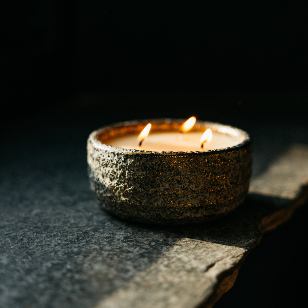 Winter Thyme Small Alchemy Pot Candle lit with three flames in a cosy festive setting