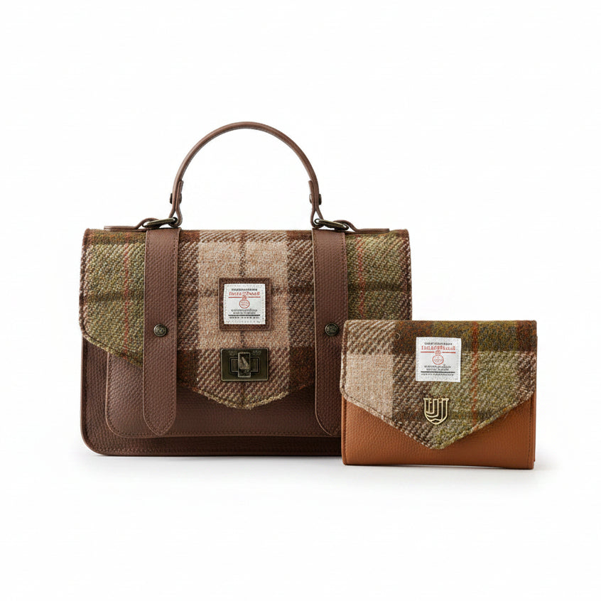 A brown and beige plaid tweed satchel bag with a top handle, shown alongside a matching small wallet on a wooden tabletop against a neutral studio background. Both items feature a white Harris Tweed label.