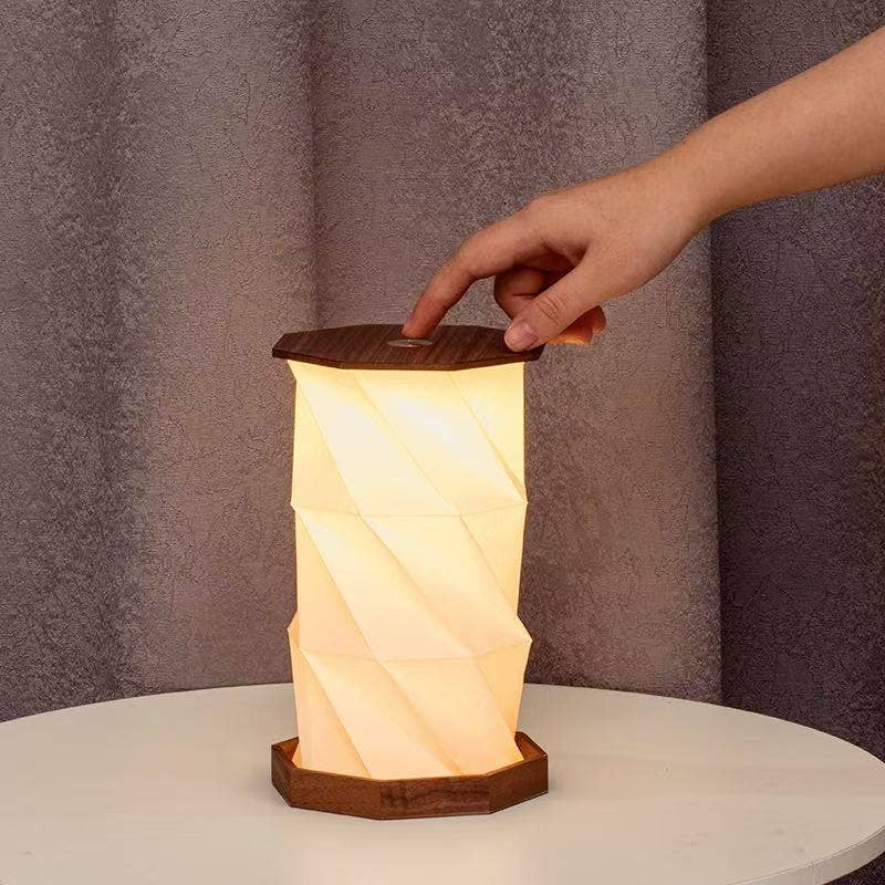 Twist Hexagon lamp walnut finish on round table with hand adjusting top
