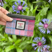 Lady holding one of the Maccessori Harris Tweed Coin Purses in Pink and blue tartan.